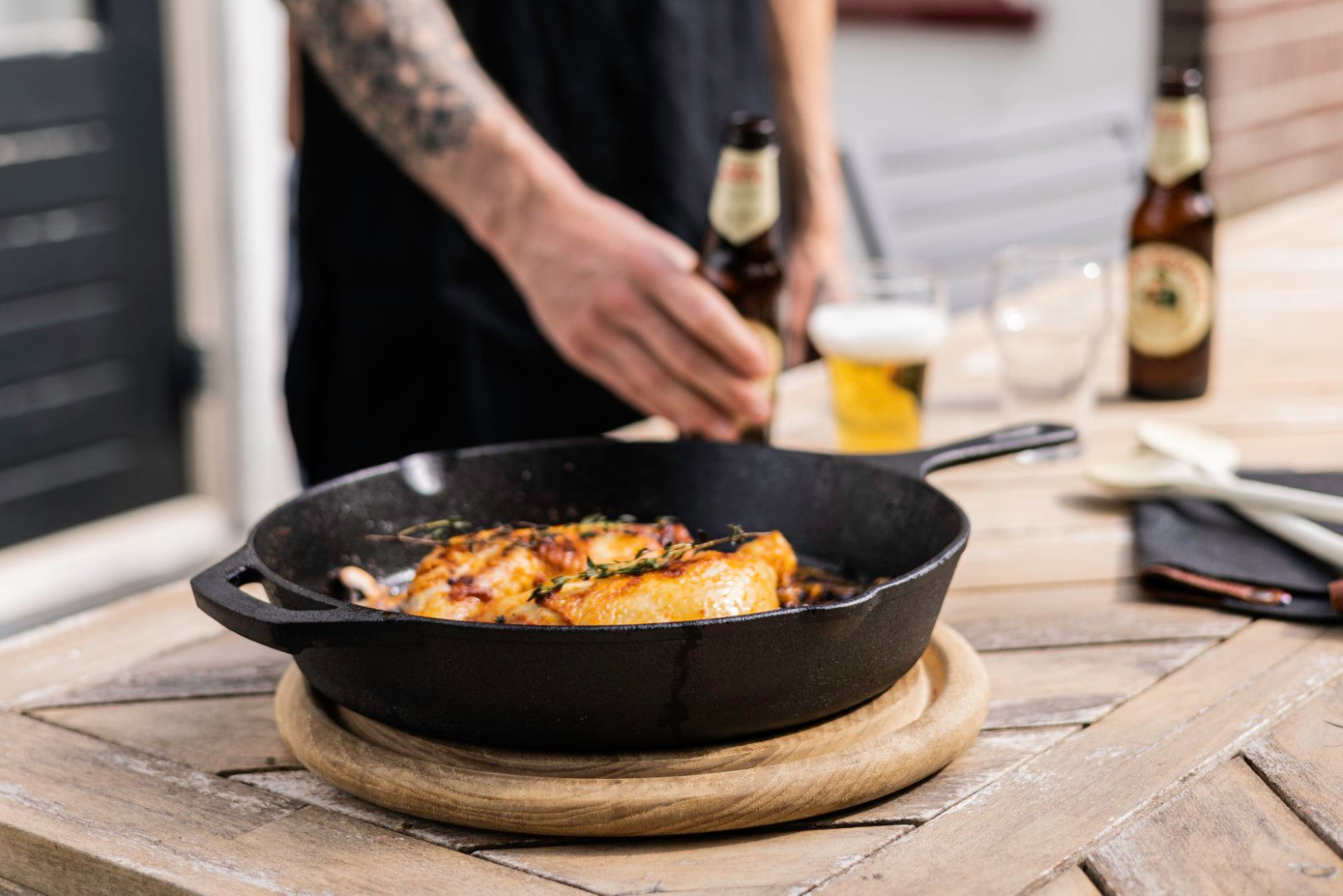 Robuuste gietijzeren skillet van Kitchenz die boven een open kampvuur hangt in de natuur, ideaal voor bushcraft en avontuurlijk koken. Keywords: kampvuur pan, gietijzeren skillet outdoor, Kitchenz bushcraft tools, koken op open vuur, survival koken gietijzer, avontuurlijk kookgerei.