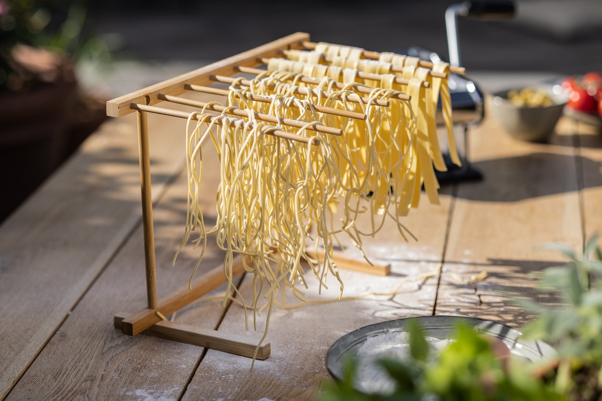 Een functioneel droogrek van natuurlijk beukenhout met acht uitklapbare armen, ontworpen om verse slierten pasta gelijkmatig te laten drogen zonder plakken. 
8-stoks pastarek, Kitchenz houten droogstation, vers deeg droogrek, keukenaccessoire voor pasta, inklapbaar droogsysteem, ambachtelijk pastagereedschap.