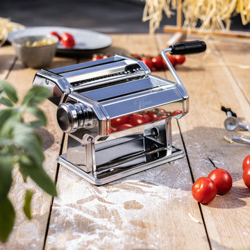 Een glanzende, zilverkleurige Kitchenz pastamachine van gepolijst chroom met een stevige tafelklem en een verstelbare knop voor verschillende diktes van lasagnebladen.
chrome pastamachine, Kitchenz zilveren deegroller, rvs look pastawals, klassieke pastasnijder metaal, Kitchenz Italiaans design, duurzame handmatige pastamaker.