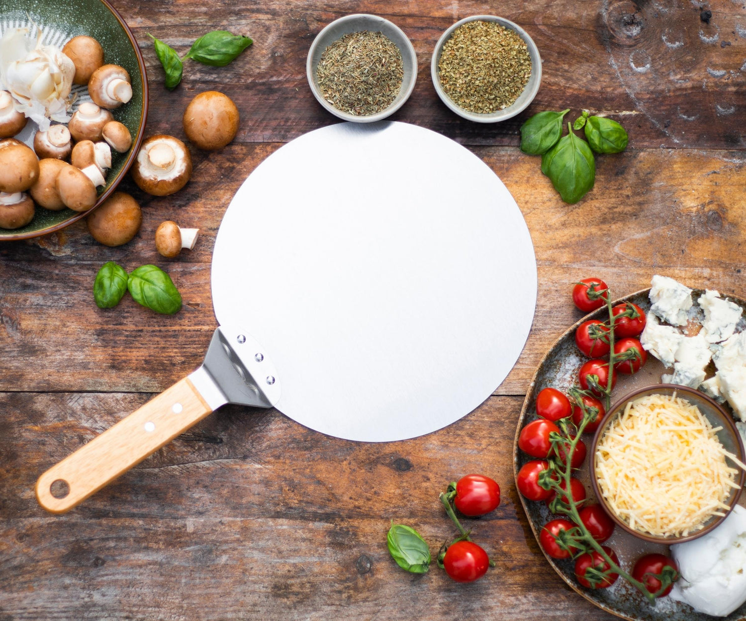 Een actiefoto op een sfeervol verlicht terras waar een vers gebakken pizza met een Kitchenz pizzaschep uit een gloeiend hete buitenoven wordt gehaald.  
pizzaschep lifestyle, Kitchenz pizza avond, buiten koken met de kamado, ambachtelijk pizza bakken, Kitchenz terras inspiratie, pizzatools in gebruik.